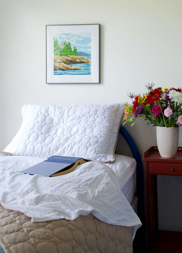 House on Ocean Point, jigsaw print by Hannah Phelps, hanging over a bed